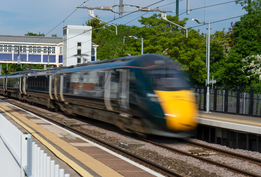High speed train passing through a station at speed.