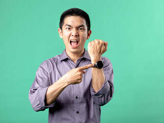 A portrait of an Asian man wearing a purple shirt, Looks like he's pointing at his watch, isolated...
