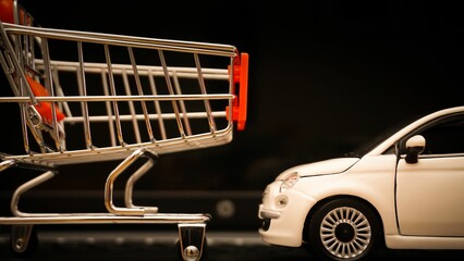 Fototapeta na wymiar Miniature shopping cart and a car