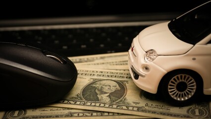 Obraz premium Car expenses concept with miniature toy car on and mouse on dollar bills