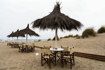 Scenic view of the tables in the outdoor bar at a Beach in Grosseto, Italy - obrazy, fototapety, plakaty