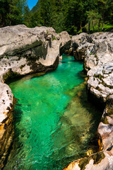 Amazing wild water in mala korita Soce valley, small pure clear turquoise flowing stream through stones gorge
