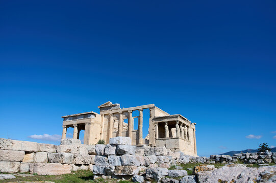 The ancient Parthenon temple in the Acropolis of Athens, Greece on a bright blue background. Remains of the building. Archaeological monument. Horizontal photo