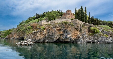 Fototapeta na wymiar Distant view of the Saint John church on the cliff surrounded by Lake Ohrid in North Macedonia
