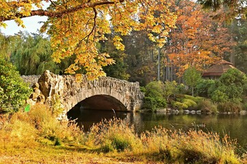 Small stone bridge over a pond in the park