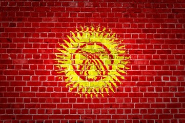 The Kyrgyzstan flag painted on a brick wall in an urban location