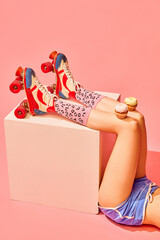 Slender female legs in vintage rollers and funny socks with delicious muffins, cakes against pink background. Party and celebration. Concept of pop art photography, creative vision, imagination.