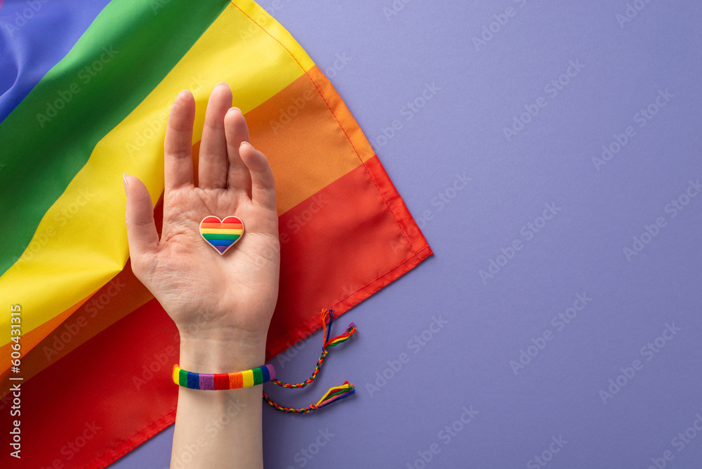 Canvas Prints a first person top view of symbolic rainbow-colored bracelet adorns a girl's hand holding a heart-sh