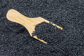 Pile of black cumin as background, spice or seasoning as background. Black cumin seeds in wooden...