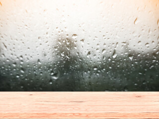Wood table top on Rain drops on clear window blur. wet home window with raindrops after summer rain. can be used for display or montage your products