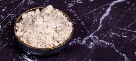 Fototapeta na wymiar Garlic powder on wooden background. Dried ground garlic powder spices in wooden bowl. Copy space. Empty space for text