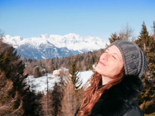 Ragazza baciata dal sole in montagna si gode la luce, montagne sullo sfondo