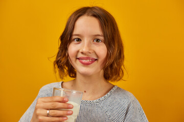 Pretty teen girl, child with a fresh glass of milk