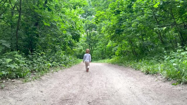 A little girl is running on a path in the park