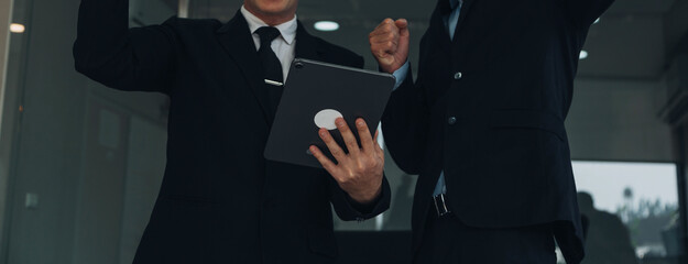 Financial analysts analyze business financial reports on a digital tablet planning investment project during a discussion at a meeting of corporate showing the results of their successful teamwork.