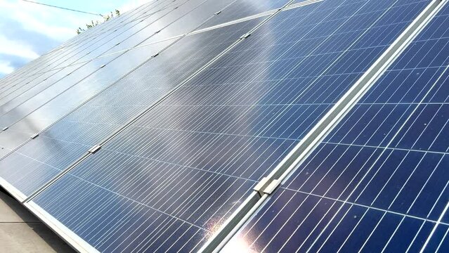 Closeup of surface of blue photovoltaic solar panels mounted on building roof for producing clean ecological electricity. Production of renewable energy concept