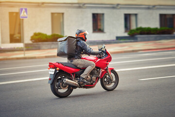 Moto food delivery,  man rides motor bike with thermal backpack. Food deliver service, moto courier delivering orders. Motorcyclist deliver food from restaurant, pizza takeaway - obrazy, fototapety, plakaty