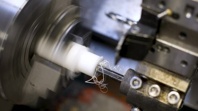 An automated lathe turns a textolite product in automatic mode. Production industrial video