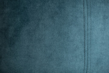 Fleecy turquoise-blue upholstery fabric stitched with thread stitching. Close-up of a seam on a velvet fabric.