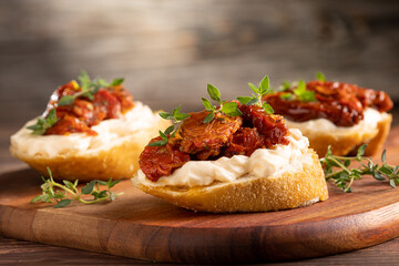 Bruschetta with sun-dried tomatoes, cream cheese and greens.