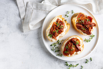 Bruschetta with sun-dried tomatoes, cream cheese and greens.