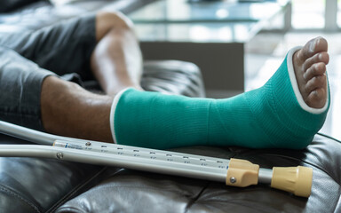 Bone fracture foot and leg on male patient with splint cast and crutches during surgery...