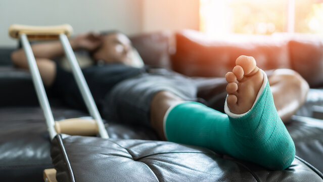 Bone Fracture Foot And Leg On Male Patient With Splint Cast And Crutches During Surgery Rehabilitation And Orthopaedic Recovery Staying At Home