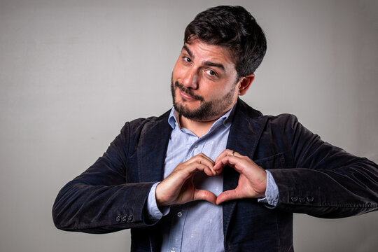 Hombre elegante formando un coraz&oacute;n con las manos en se&ntilde;al de amor y gusto