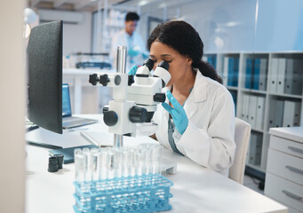 Science, investigation and microscope with a woman at work in a laboratory for research or...