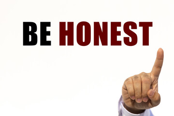 Be honest text on white wall background with businessman's finger point at the message with empty space. This message can be used as business concept about be honest.