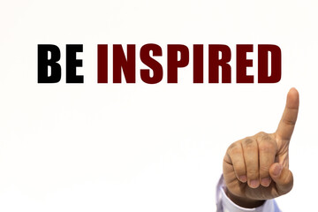 Be inspired text on white wall background with businessman's finger point at the message with empty space. This message can be used as business concept about be inspired.