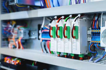 Several batch switches in an electrical control cabinet on a production line surrounded by inverters and control wiring
