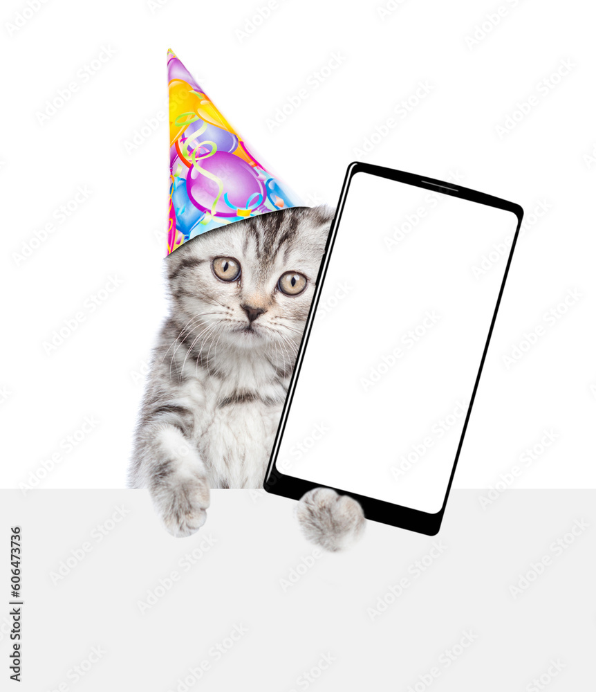 Poster cute kitten wearing party cap shows big smartphone with blank screen above empty white banner. isola