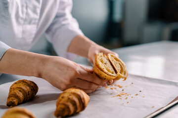 woman baker shows ready cut freshly baked hot crispy aromatic croissants and checks dough baking...