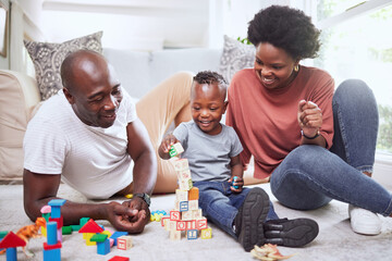 Building blocks, games and black family playing on a living room floor happy, love and bonding in...
