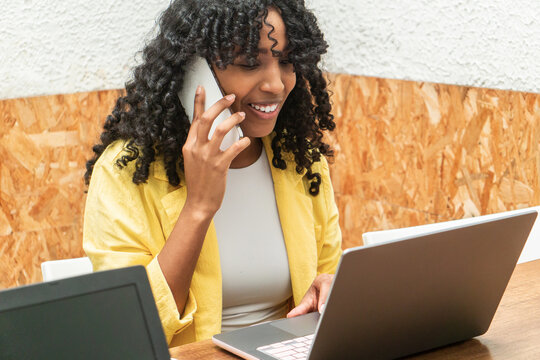 Happy Black Woman Talking On Mobile Phone In Office While Working