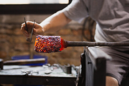 Artigiano realizza un vaso in vetro soffiato a murano
