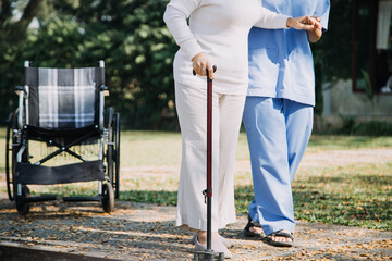 young asian physical therapist working with senior woman on walking with a walker