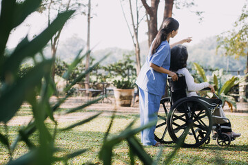 Obraz premium young asian physical therapist working with senior woman on walking with a walker