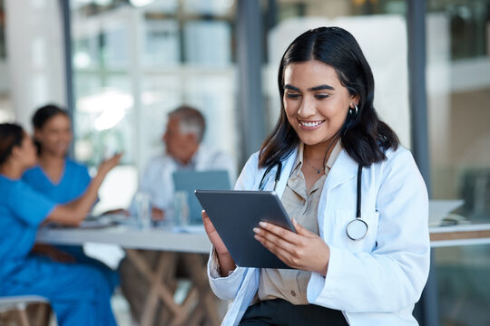 Hospital, doctor and Indian woman on tablet for medical analysis, research and report in meeting. Healthcare, clinic and female nurse on digital tech for wellness app, online consulting and service