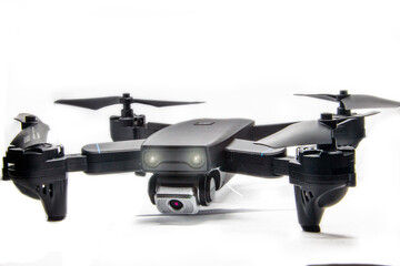 dark gray quadrocopter on a white background with glowing headlights and glare	
