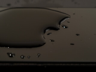Water has been spilled on the Smartphone. The smartphone fell into the water. Wet smartphone on a black background.
