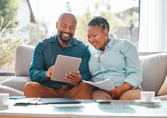 Fotobehang Technology, married couple with tablet and documents for pay their bills in a living room of their home. Finance or loan, budget or payment and black people with paper on a couch happy together © N Lawrenson/peopleimages.com