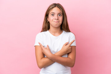 Fototapeta premium Little caucasian girl isolated on pink background pointing to the laterals having doubts