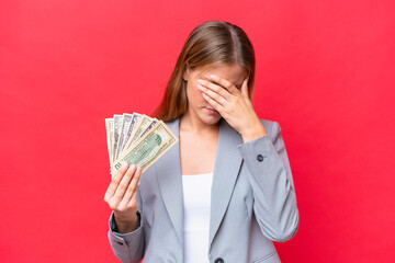 Young business caucasian woman holding money isolated on red background with tired and sick...