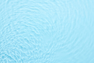 Fototapeta na wymiar Water blue surface abstract background. Waves and ripples of cosmetic moisturizer with bubbles