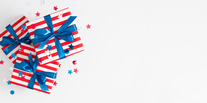 4th of July, USA Presidents Day, Independence Day, Memorial day, US election concept. Stack of gift striped boxes with satin bow, confetti stars on white background. Flat lay, top view, copy space