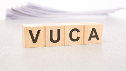 vuca word written on wood cubes with white background