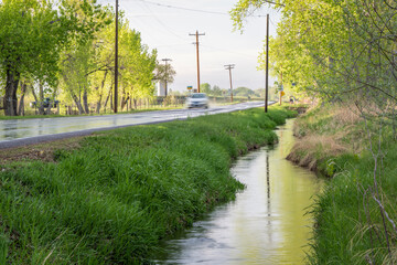 irrigation ditch and wet backcountry road in Colorado after springtime showers
