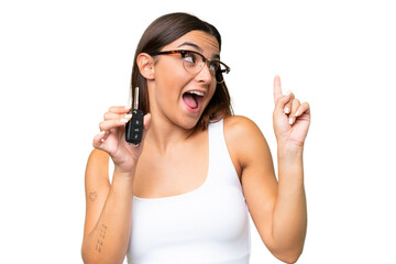 Young caucasian woman holding car keys isolated on green chroma background background intending to realizes the solution while lifting a finger up